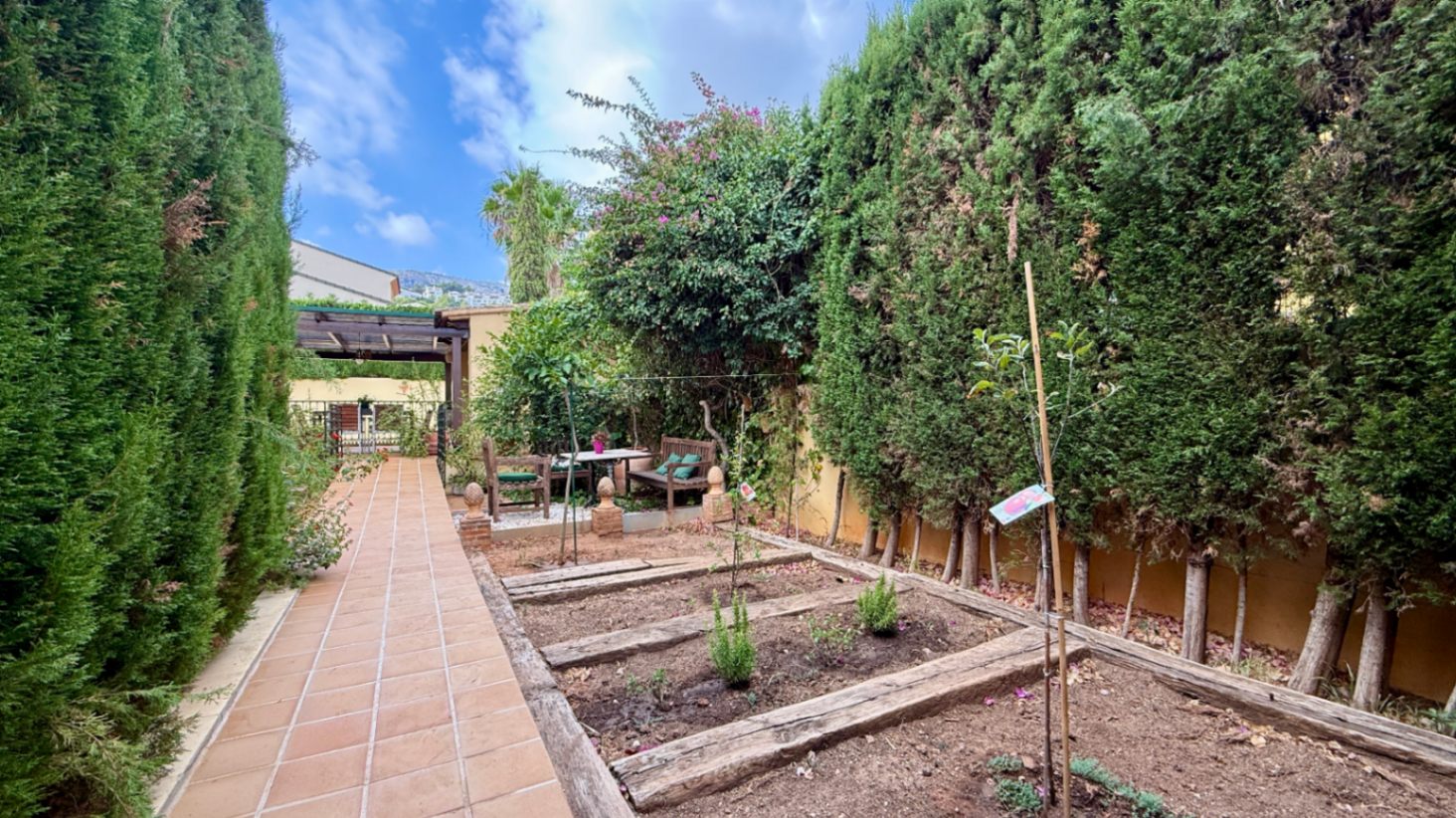 Ruim villa met zwembad, grote kelder en maximale privacy in Dénia Gelegen in een van de rustigste woonwijken van Dénia, combineert deze prachtige villa privacy, ruimte en een uitstekende verbinding met het stadscentrum. Gebouwd op een perceel van 811 m², omgeven door groen, biedt het een verzorgde en besloten omgeving, ideaal om te genieten van de rust zonder in te boeten op alle voorzieningen. De woning beschikt over vier slaapkamers, verdeeld over twee verdiepingen, en ruime, lichte ruimtes die zijn ontworpen voor dagelijks comfort. De keuken, van royale afmetingen, functioneert ook als eetkamer en ontvangt veel natuurlijk licht dankzij de grote ramen. Op de bovenverdieping bevindt zich een aparte kantoorruimte en de hoofdsuite, die beschikt over een eigen badkamer, inloopkast en balkon. Buiten steekt een mooie tuin met eigen bronirrigatie, een zwembad van 9 x 5 meter dat perfect in de omgeving is geïntegreerd, een zomerkeuken en een ruime glazen veranda met open haard, perfect om het hele jaar door van te genieten. De woning beschikt ook over een overdekte garage en ruime buitenruimtes. Een van de grootste aantrekkingskrachten van deze villa is de grote kelder die volledig is ingericht, droog en met uitstekende natuurlijke ventilatie, een zeer veelzijdige ruimte die momenteel een fitnessruimte, speelruimte en biljart bevat, en bovendien de mogelijkheid biedt om een sauna te installeren. De woning is uitgerust met airconditioning in de woonkamer en slaapkamers, een fotovoltaïsche installatie van meer dan 6 kW, alarmsysteem, veiligheidssloten, ramen met inbraakbescherming in verschillende ruimtes, horren, aparte wasruimte, osmosewater in de keuken, een olieopslag van 1.000 liter, aansluiting op het riolering en een compleet drainsysteem dat de kelder beschermt tegen vocht. Een eigendom van uitstekende constructkwaliteit, met ruime binnen- en buitenruimtes, ideaal als permanente woning of om het hele jaar van de Costa Blanca te genieten.