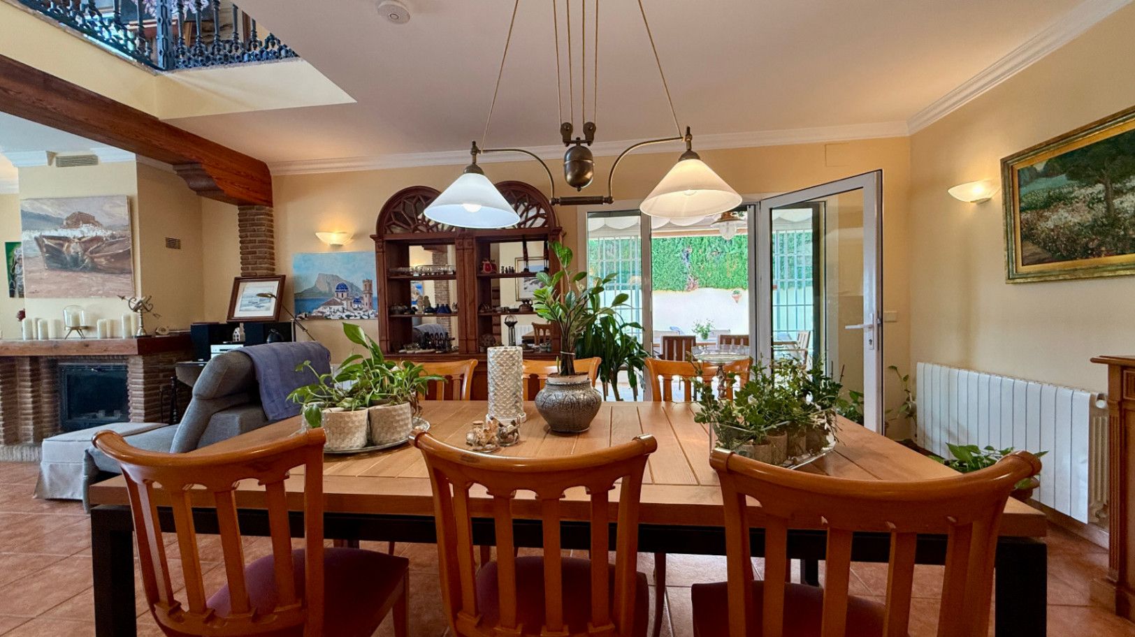 Ruim villa met zwembad, grote kelder en maximale privacy in Dénia Gelegen in een van de rustigste woonwijken van Dénia, combineert deze prachtige villa privacy, ruimte en een uitstekende verbinding met het stadscentrum. Gebouwd op een perceel van 811 m², omgeven door groen, biedt het een verzorgde en besloten omgeving, ideaal om te genieten van de rust zonder in te boeten op alle voorzieningen. De woning beschikt over vier slaapkamers, verdeeld over twee verdiepingen, en ruime, lichte ruimtes die zijn ontworpen voor dagelijks comfort. De keuken, van royale afmetingen, functioneert ook als eetkamer en ontvangt veel natuurlijk licht dankzij de grote ramen. Op de bovenverdieping bevindt zich een aparte kantoorruimte en de hoofdsuite, die beschikt over een eigen badkamer, inloopkast en balkon. Buiten steekt een mooie tuin met eigen bronirrigatie, een zwembad van 9 x 5 meter dat perfect in de omgeving is geïntegreerd, een zomerkeuken en een ruime glazen veranda met open haard, perfect om het hele jaar door van te genieten. De woning beschikt ook over een overdekte garage en ruime buitenruimtes. Een van de grootste aantrekkingskrachten van deze villa is de grote kelder die volledig is ingericht, droog en met uitstekende natuurlijke ventilatie, een zeer veelzijdige ruimte die momenteel een fitnessruimte, speelruimte en biljart bevat, en bovendien de mogelijkheid biedt om een sauna te installeren. De woning is uitgerust met airconditioning in de woonkamer en slaapkamers, een fotovoltaïsche installatie van meer dan 6 kW, alarmsysteem, veiligheidssloten, ramen met inbraakbescherming in verschillende ruimtes, horren, aparte wasruimte, osmosewater in de keuken, een olieopslag van 1.000 liter, aansluiting op het riolering en een compleet drainsysteem dat de kelder beschermt tegen vocht. Een eigendom van uitstekende constructkwaliteit, met ruime binnen- en buitenruimtes, ideaal als permanente woning of om het hele jaar van de Costa Blanca te genieten.