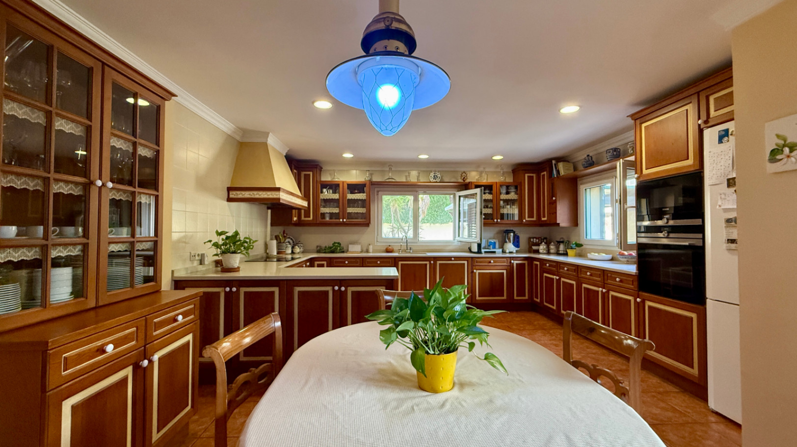 Ruim villa met zwembad, grote kelder en maximale privacy in Dénia Gelegen in een van de rustigste woonwijken van Dénia, combineert deze prachtige villa privacy, ruimte en een uitstekende verbinding met het stadscentrum. Gebouwd op een perceel van 811 m², omgeven door groen, biedt het een verzorgde en besloten omgeving, ideaal om te genieten van de rust zonder in te boeten op alle voorzieningen. De woning beschikt over vier slaapkamers, verdeeld over twee verdiepingen, en ruime, lichte ruimtes die zijn ontworpen voor dagelijks comfort. De keuken, van royale afmetingen, functioneert ook als eetkamer en ontvangt veel natuurlijk licht dankzij de grote ramen. Op de bovenverdieping bevindt zich een aparte kantoorruimte en de hoofdsuite, die beschikt over een eigen badkamer, inloopkast en balkon. Buiten steekt een mooie tuin met eigen bronirrigatie, een zwembad van 9 x 5 meter dat perfect in de omgeving is geïntegreerd, een zomerkeuken en een ruime glazen veranda met open haard, perfect om het hele jaar door van te genieten. De woning beschikt ook over een overdekte garage en ruime buitenruimtes. Een van de grootste aantrekkingskrachten van deze villa is de grote kelder die volledig is ingericht, droog en met uitstekende natuurlijke ventilatie, een zeer veelzijdige ruimte die momenteel een fitnessruimte, speelruimte en biljart bevat, en bovendien de mogelijkheid biedt om een sauna te installeren. De woning is uitgerust met airconditioning in de woonkamer en slaapkamers, een fotovoltaïsche installatie van meer dan 6 kW, alarmsysteem, veiligheidssloten, ramen met inbraakbescherming in verschillende ruimtes, horren, aparte wasruimte, osmosewater in de keuken, een olieopslag van 1.000 liter, aansluiting op het riolering en een compleet drainsysteem dat de kelder beschermt tegen vocht. Een eigendom van uitstekende constructkwaliteit, met ruime binnen- en buitenruimtes, ideaal als permanente woning of om het hele jaar van de Costa Blanca te genieten.