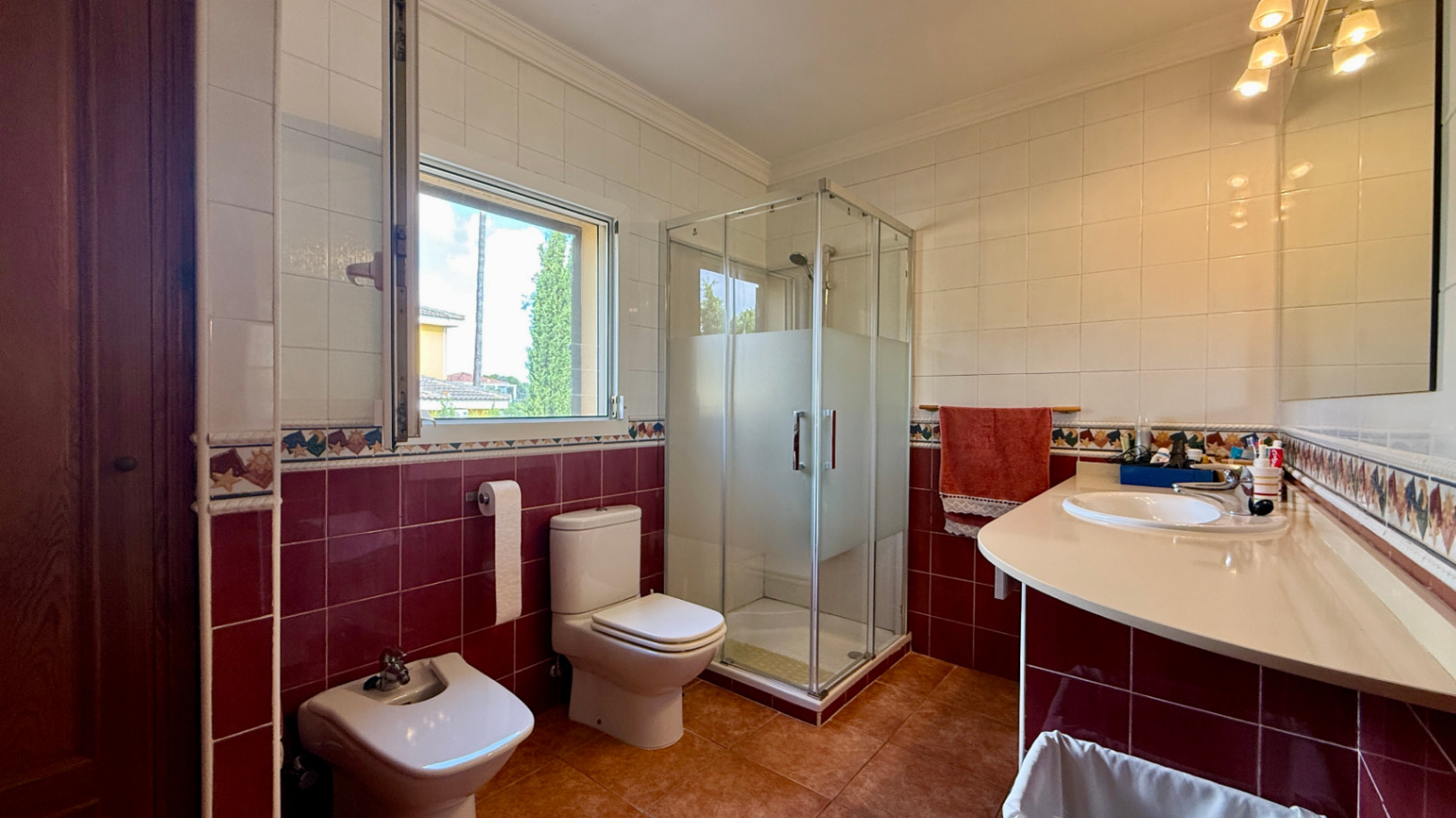 Ruim villa met zwembad, grote kelder en maximale privacy in Dénia Gelegen in een van de rustigste woonwijken van Dénia, combineert deze prachtige villa privacy, ruimte en een uitstekende verbinding met het stadscentrum. Gebouwd op een perceel van 811 m², omgeven door groen, biedt het een verzorgde en besloten omgeving, ideaal om te genieten van de rust zonder in te boeten op alle voorzieningen. De woning beschikt over vier slaapkamers, verdeeld over twee verdiepingen, en ruime, lichte ruimtes die zijn ontworpen voor dagelijks comfort. De keuken, van royale afmetingen, functioneert ook als eetkamer en ontvangt veel natuurlijk licht dankzij de grote ramen. Op de bovenverdieping bevindt zich een aparte kantoorruimte en de hoofdsuite, die beschikt over een eigen badkamer, inloopkast en balkon. Buiten steekt een mooie tuin met eigen bronirrigatie, een zwembad van 9 x 5 meter dat perfect in de omgeving is geïntegreerd, een zomerkeuken en een ruime glazen veranda met open haard, perfect om het hele jaar door van te genieten. De woning beschikt ook over een overdekte garage en ruime buitenruimtes. Een van de grootste aantrekkingskrachten van deze villa is de grote kelder die volledig is ingericht, droog en met uitstekende natuurlijke ventilatie, een zeer veelzijdige ruimte die momenteel een fitnessruimte, speelruimte en biljart bevat, en bovendien de mogelijkheid biedt om een sauna te installeren. De woning is uitgerust met airconditioning in de woonkamer en slaapkamers, een fotovoltaïsche installatie van meer dan 6 kW, alarmsysteem, veiligheidssloten, ramen met inbraakbescherming in verschillende ruimtes, horren, aparte wasruimte, osmosewater in de keuken, een olieopslag van 1.000 liter, aansluiting op het riolering en een compleet drainsysteem dat de kelder beschermt tegen vocht. Een eigendom van uitstekende constructkwaliteit, met ruime binnen- en buitenruimtes, ideaal als permanente woning of om het hele jaar van de Costa Blanca te genieten.